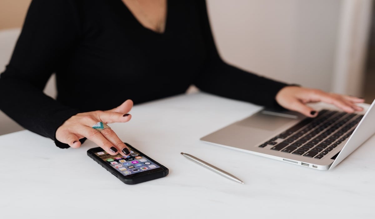 Une femme s'apprête à tracer un numéro de téléphone de famille avec ses appareils iOS.
