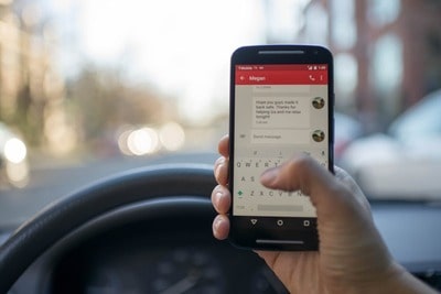 Una mujer utiliza su smartphone para enviar un mensaje de texto con su ubicación.