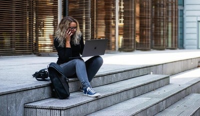 A woman tries to locate an international area code using his smartphone and laptop